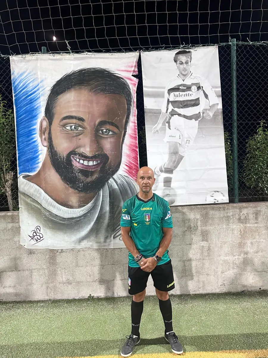 L'arbitro della serata in posa davanti ai teli dedicati ad Alessandro Morricella, in notturna