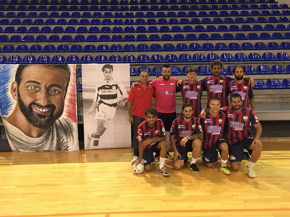 Una squadra in maglia rossoblù davanti ai teli dedicati ad Alessandro Morricella, al palazzetto